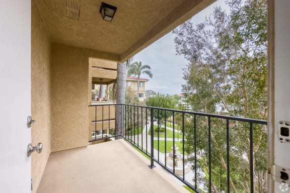 the balcony has a view of the backyard and the trees at Huntington Terrace North Senior, Huntington Beach, CA 92648