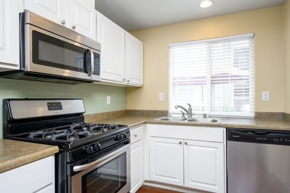 a kitchen with white cabinets and black appliances