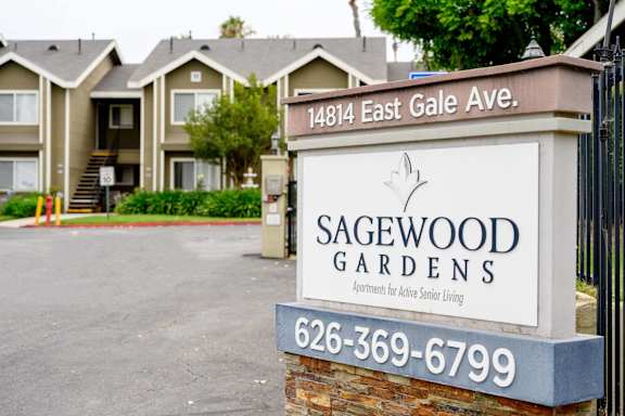 a sign in front of houses at Sagewood Gardens Senior Apartments, Hacienda Heights California