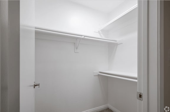 a walk in closet with a white wall and a white door at Huntington Terrace North Senior, Huntington Beach California