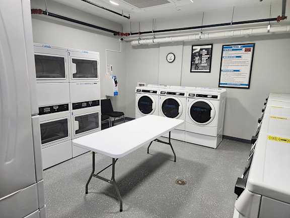216 East State laundry room with a folding table and washing and dryer machines