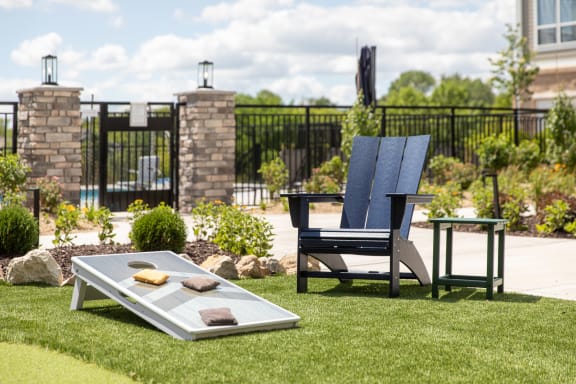 a lounge chair and a coffee table on a lawn in a backyard