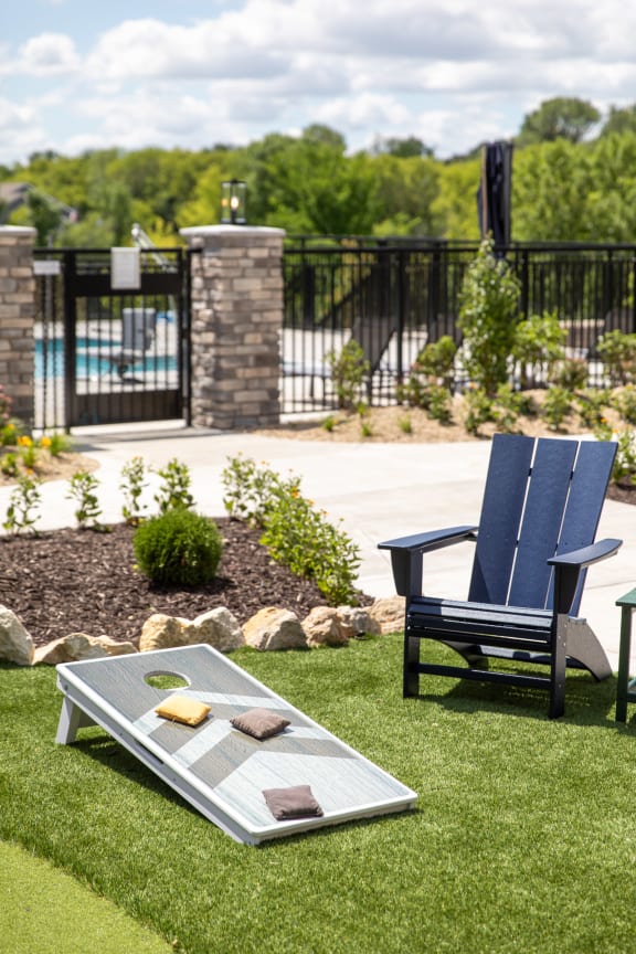 a patio with two chairs and a table on the grass