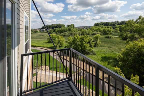 A balcony overlooks a green field.