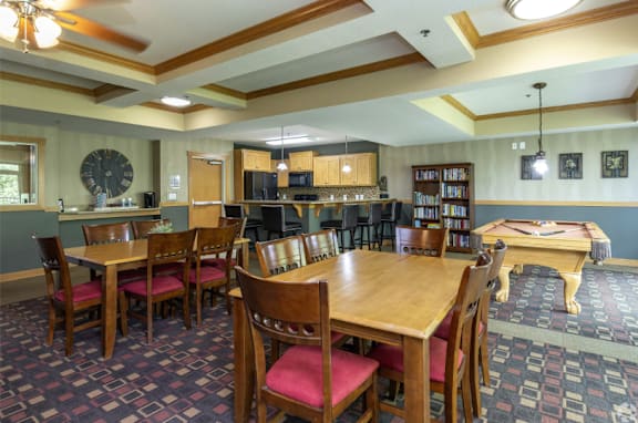 A dining room with a large table and chairs.