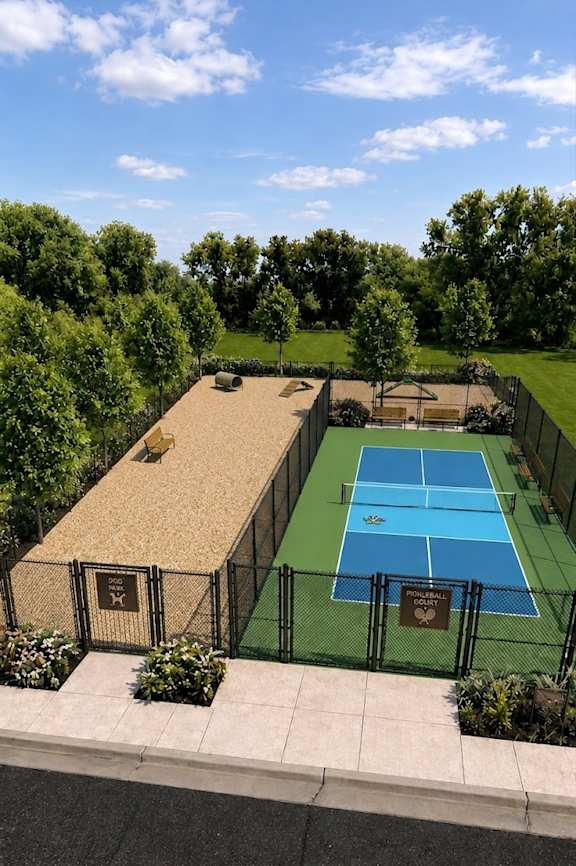 A tennis court surrounded by a fence and greenery.