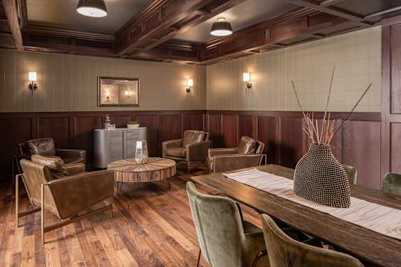 A room with brown chairs and a wooden table.
