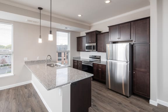 a kitchen with a large island and stainless steel appliancesat The Carver Apartments, Chaska, MN