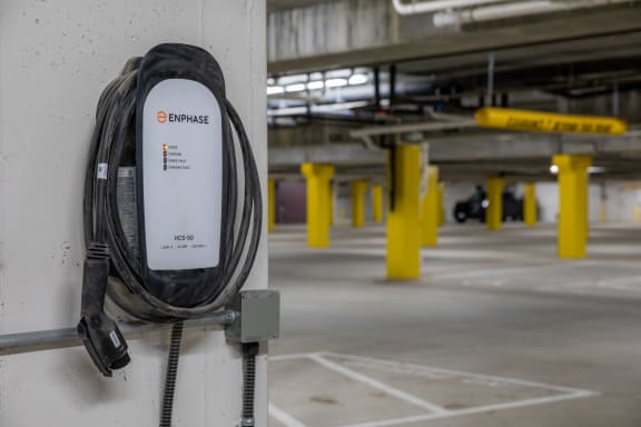 an electric cable plugged into a wall in a parking garage