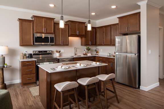 A kitchen with wooden cabinets and a stainless steel refrigerator.