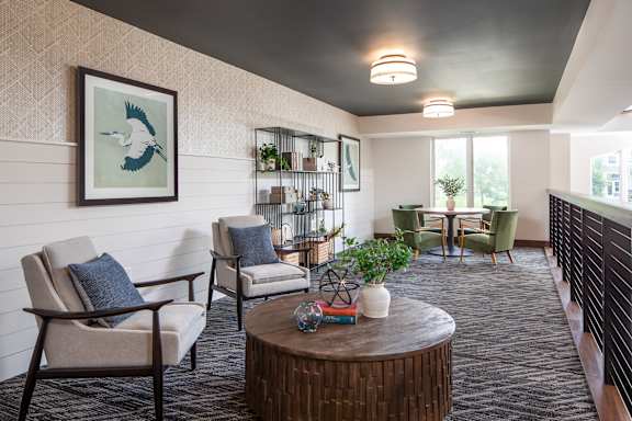A living room with a wooden coffee table and two chairs.