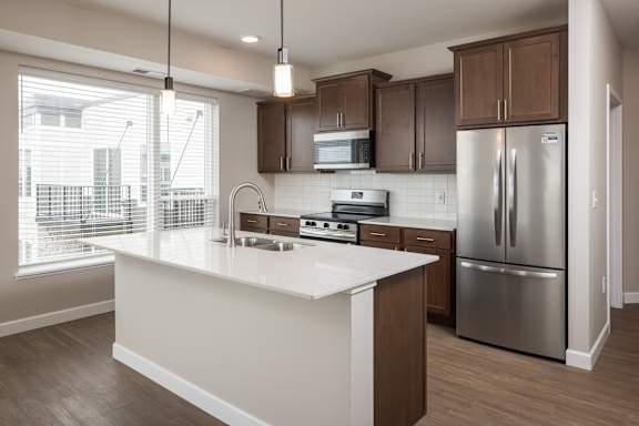 A modern kitchen with a white island and stainless steel appliances.