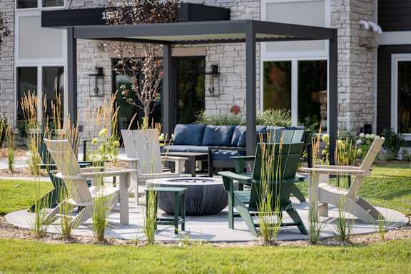 A patio with a table and chairs is set up outside a house.