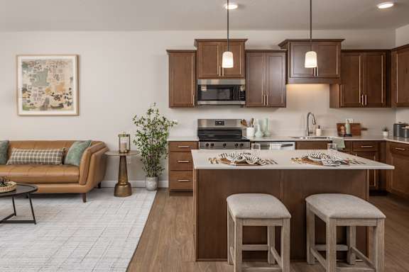 A kitchen with a couch and bar stools.
