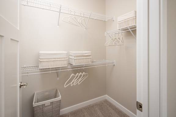 A white closet with shelves and hangers.
