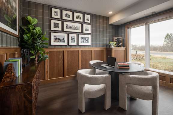 A room with a table and chairs and pictures on the wall.