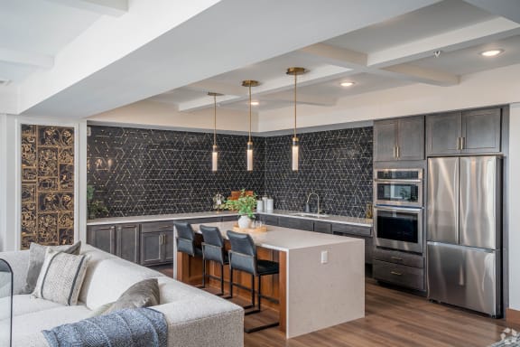 a kitchen and living room with a large island and stainless steel appliances