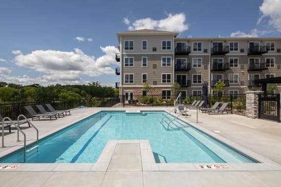 a swimming pool with an apartment building in the background