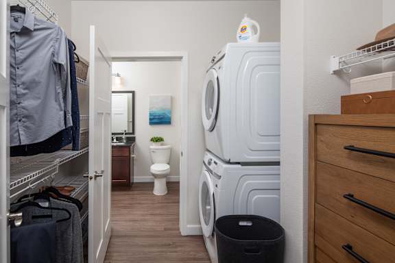 A laundry room with a stack of washers and dryers.