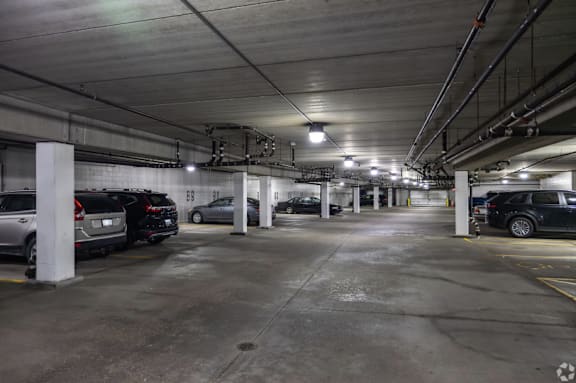 A parking garage with several cars parked.
