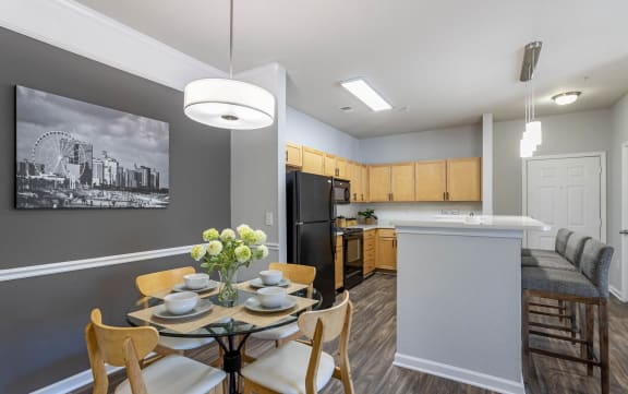 A dining room with a table set for two and a kitchen area in the background at Breakers Point, South Carolina, 29579