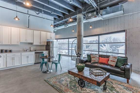 A living room with a couch, chairs, and a coffee table.