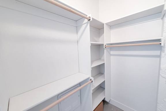 A white closet with shelves and hangers.