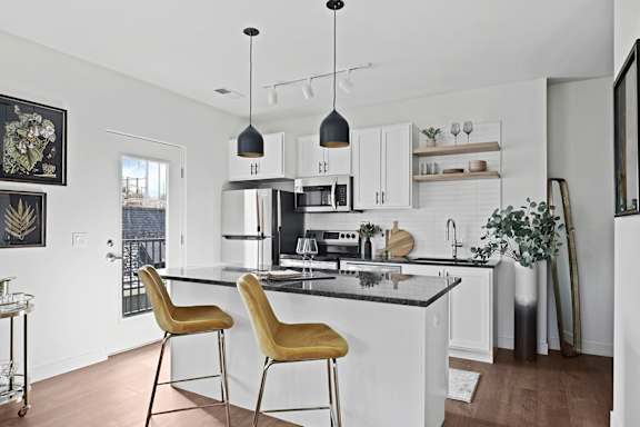 A kitchen with a black countertop and white cabinets.