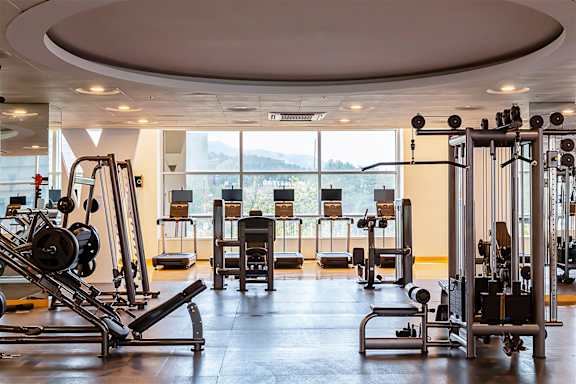 A gym with a variety of equipment including a leg press machine.