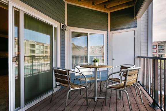 A table with chairs is on a deck.