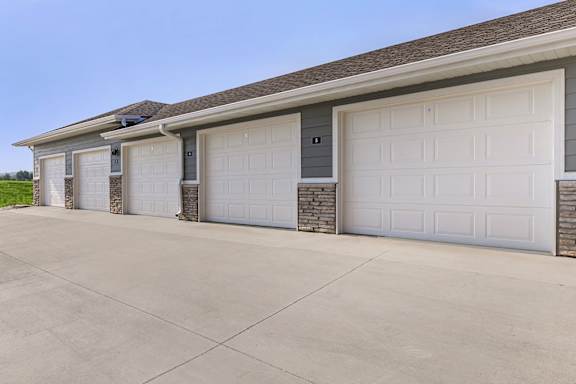 A row of garage doors in front of a house.