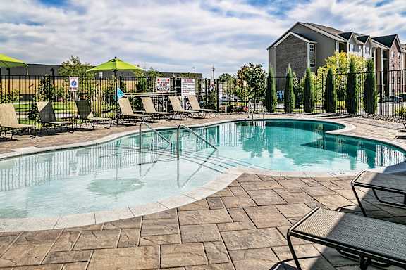 A heated pool surrounded by chairs and umbrellas.
