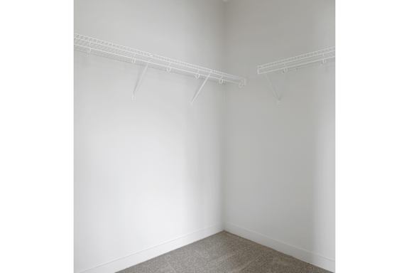 A room with two white shelves on the wall.