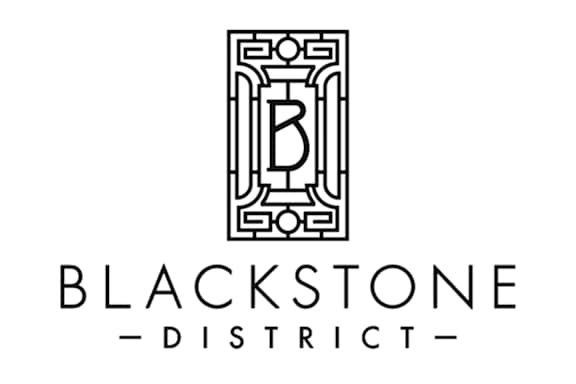 A logo with a black and white design and the words Blackstone District.