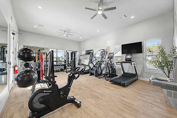 A spacious home gym with a variety of exercise equipment.