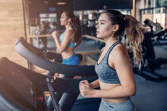 a woman running on a treadmill in a gym