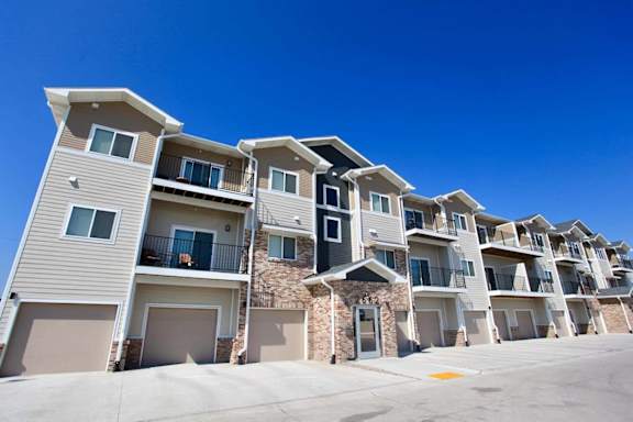 A row of modern townhouses with balconies and garages.