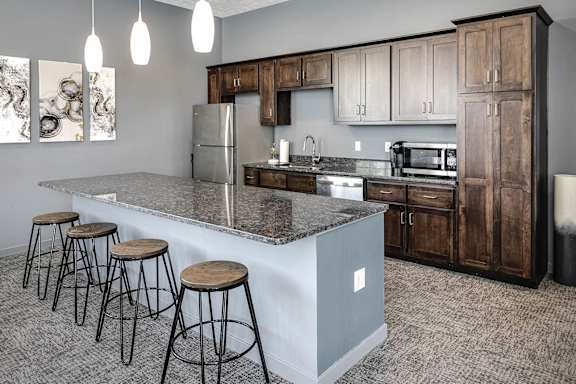 A kitchen with a bar area and stools.