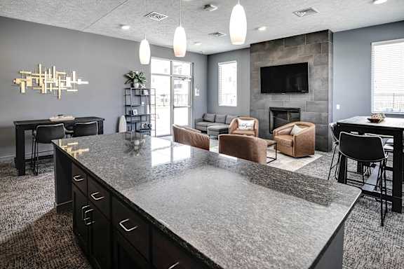 A modern kitchen with a large island and a fireplace in the living room.