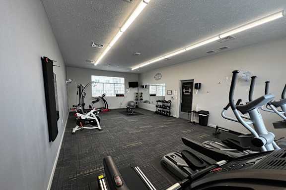 A gym with treadmills, elliptical machines, and other exercise equipment.