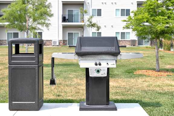 A black grill is in front of a white building.