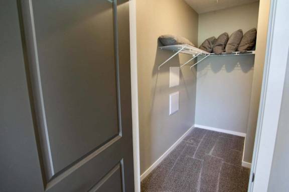 A small room with a grey carpet and a white door.