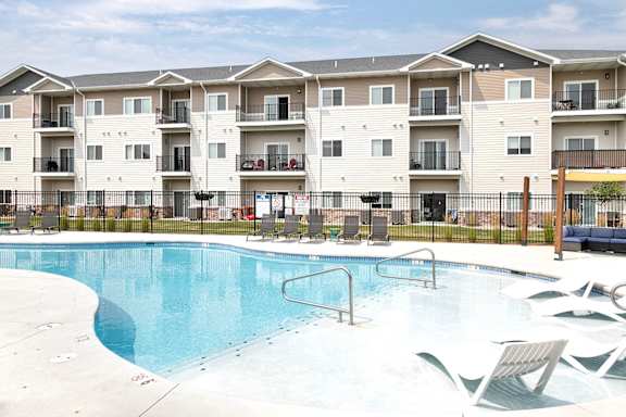 A swimming pool in front of apartment buildings.