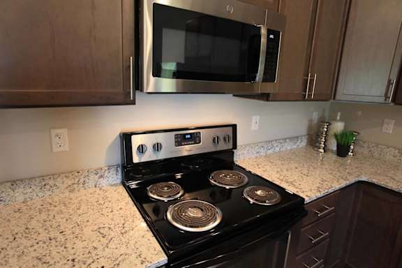 A black stove top oven with four burners and a digital display.