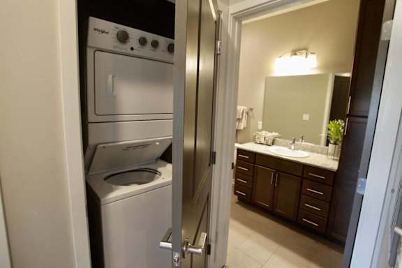 A modern kitchen with a washing machine and dryer built into the cabinetry.