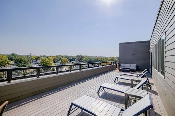 A sunny day on a wooden deck with a view of the trees.