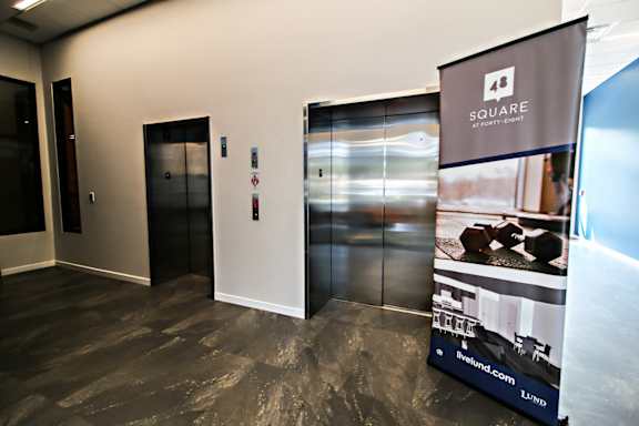 A room with a poster of a house on the wall and a glass door.