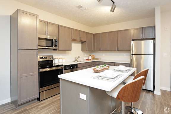 A kitchen with a table and chairs in the middle.