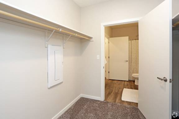 A white door is in a room with a carpet.