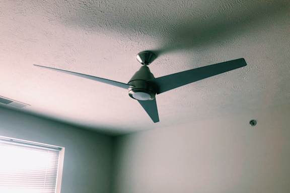 A ceiling fan is hanging from the ceiling in a room.